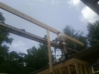 Carpenter setting a ridge beam over a new addition frame — Ice Dam Removal by Roofing Brothers in Bergholz
