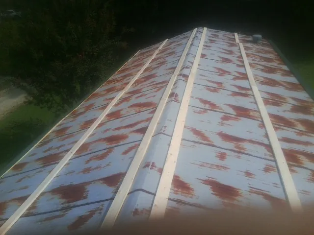Rusted metal roof panels with new wood purlins before replacement — Storm Damage Roof Repair in Bergholz by Roofing Brothers