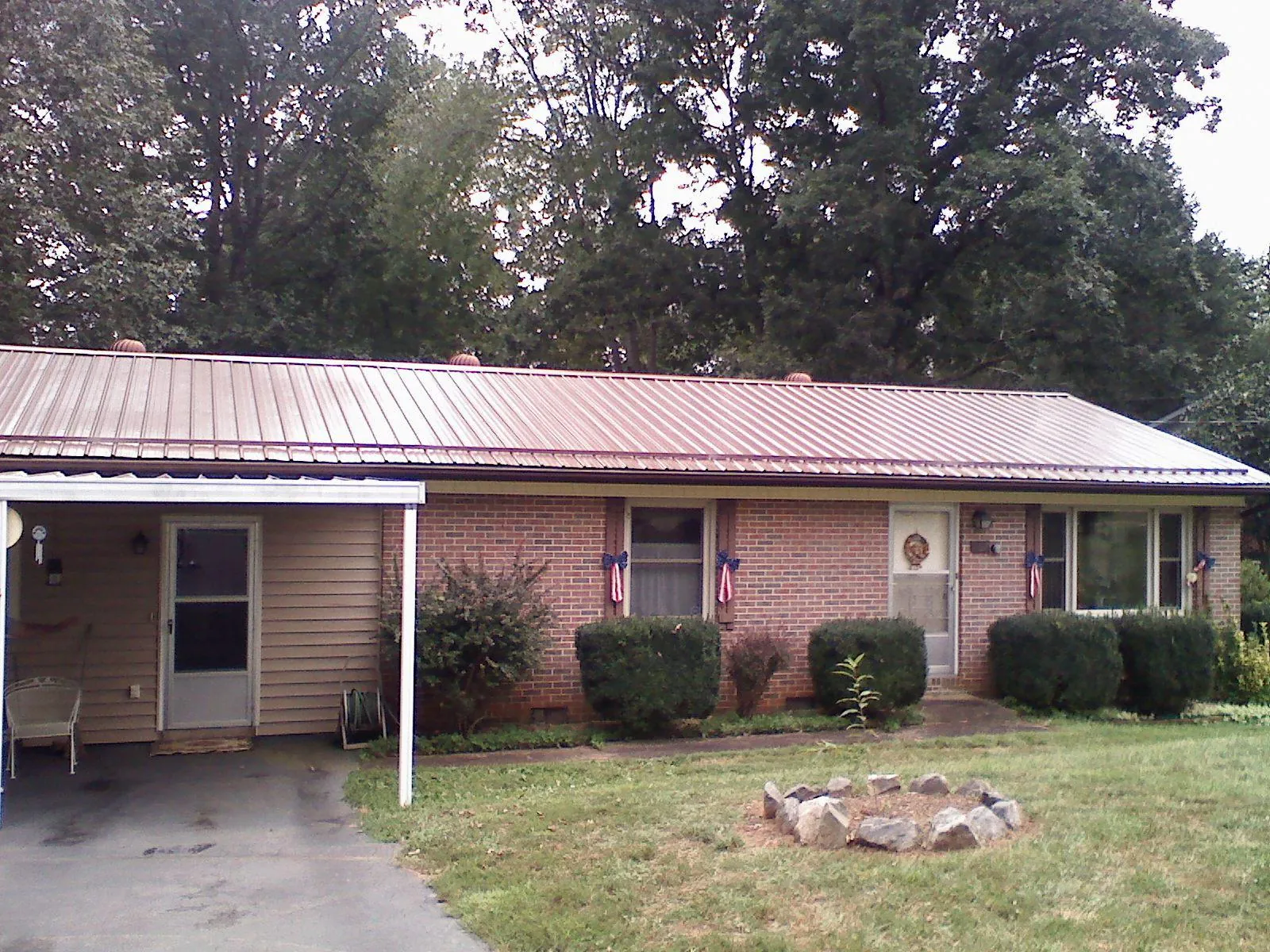 Bronze metal roof and carport on a brick ranch home — Roof Repair work by our crew in Bergholz