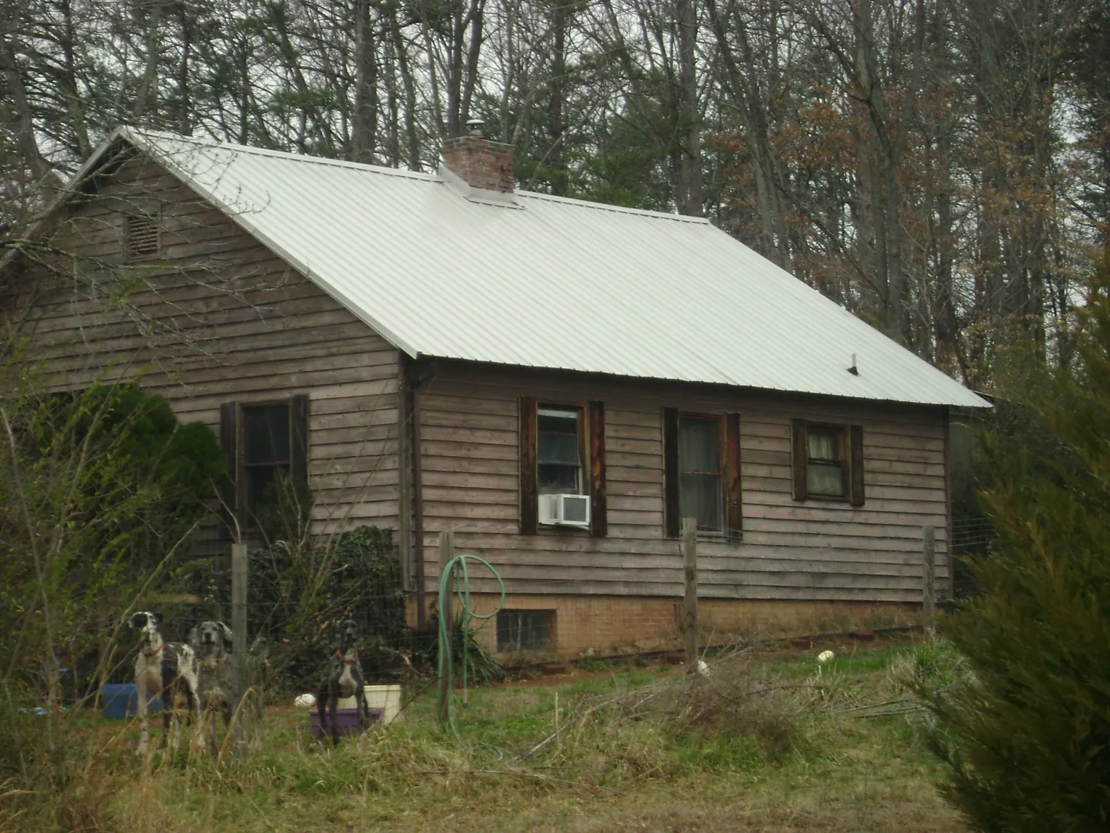 White metal roof on an old wood sided farmhouse, from a Metal Roof Installation job in Bergholz